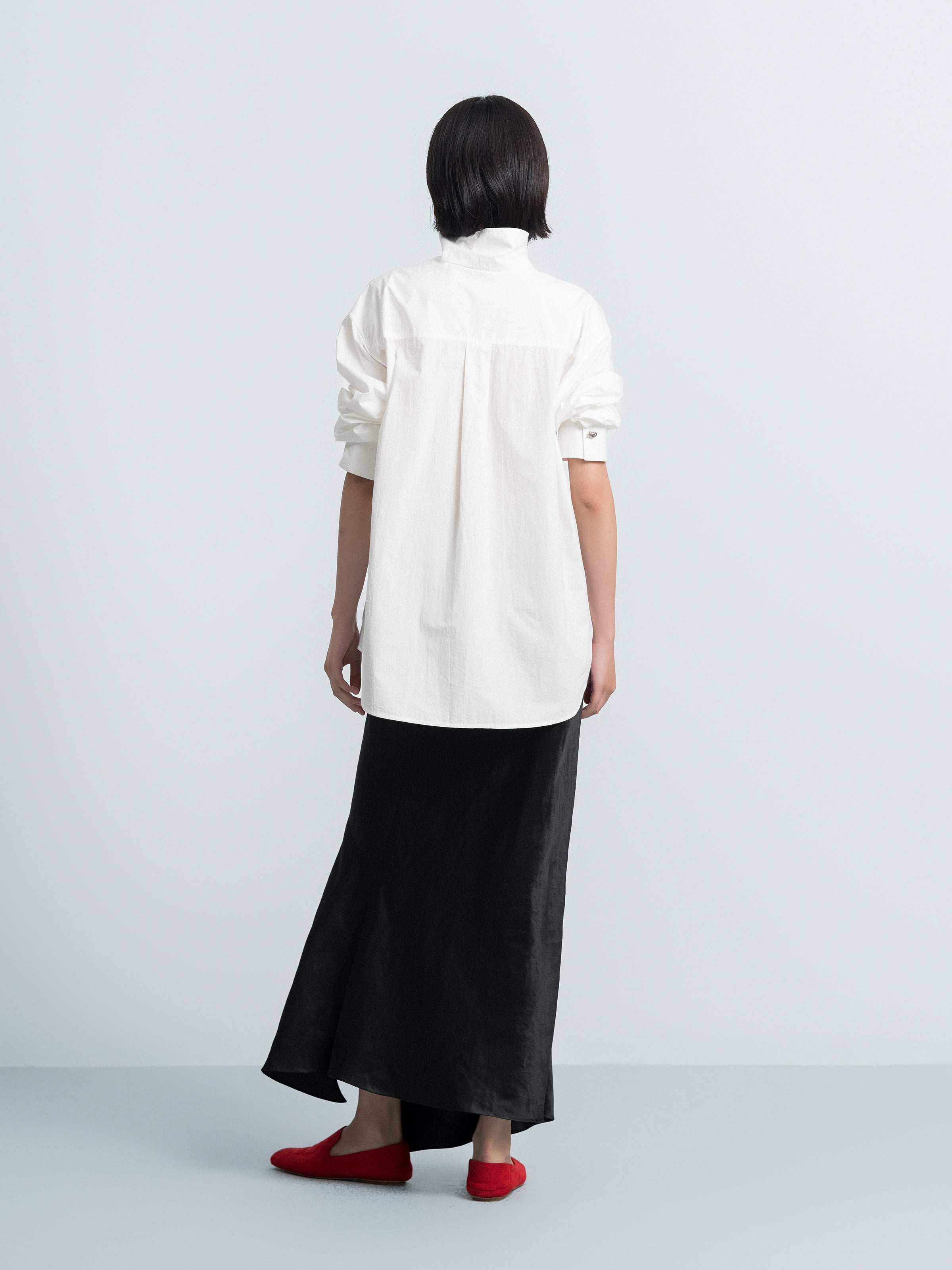 Back view of off-white oversized shirt-style top with stand collar and button detail