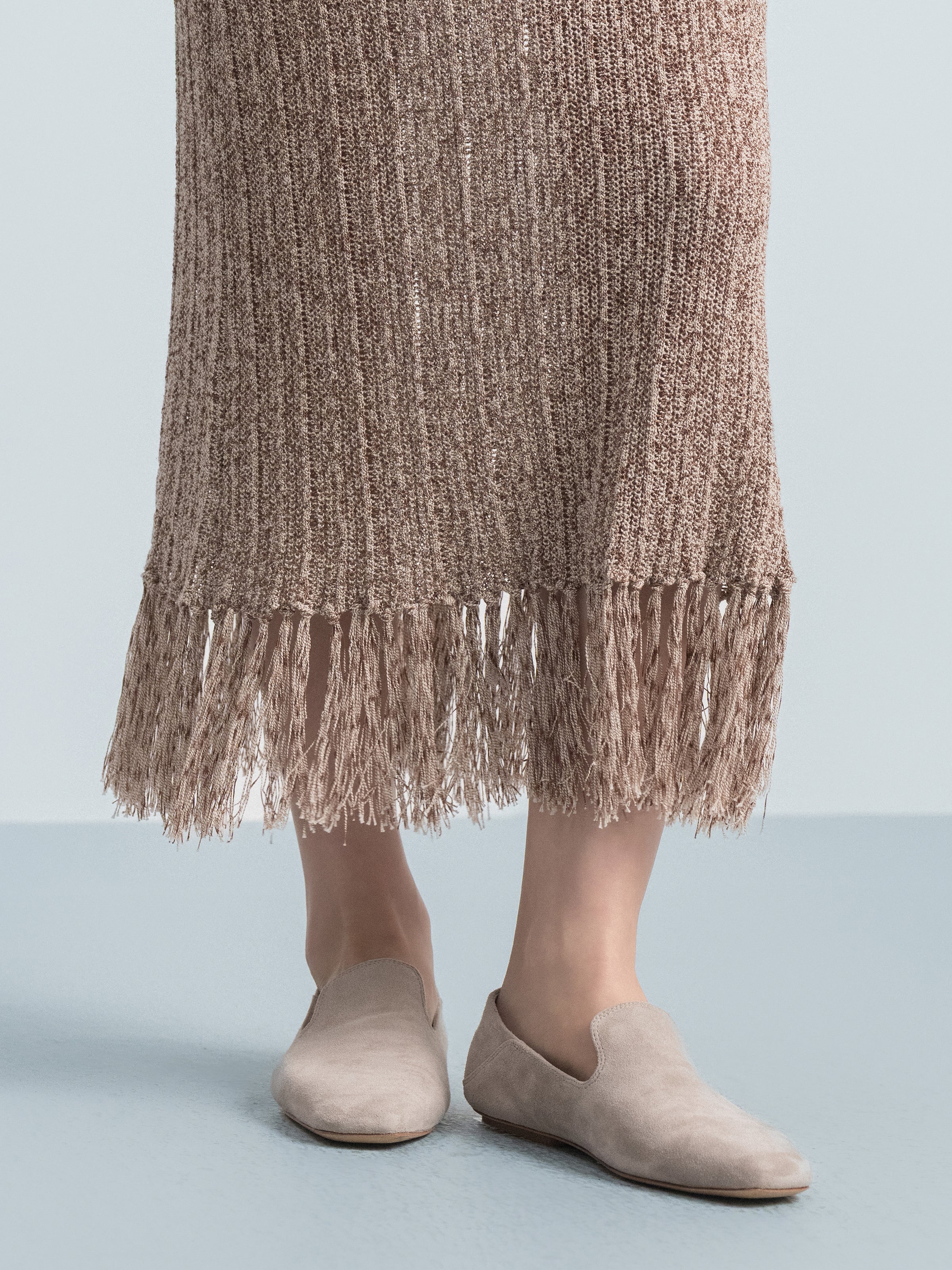 Brown knit midi skirt hem with fringed trim and textured knit surface
