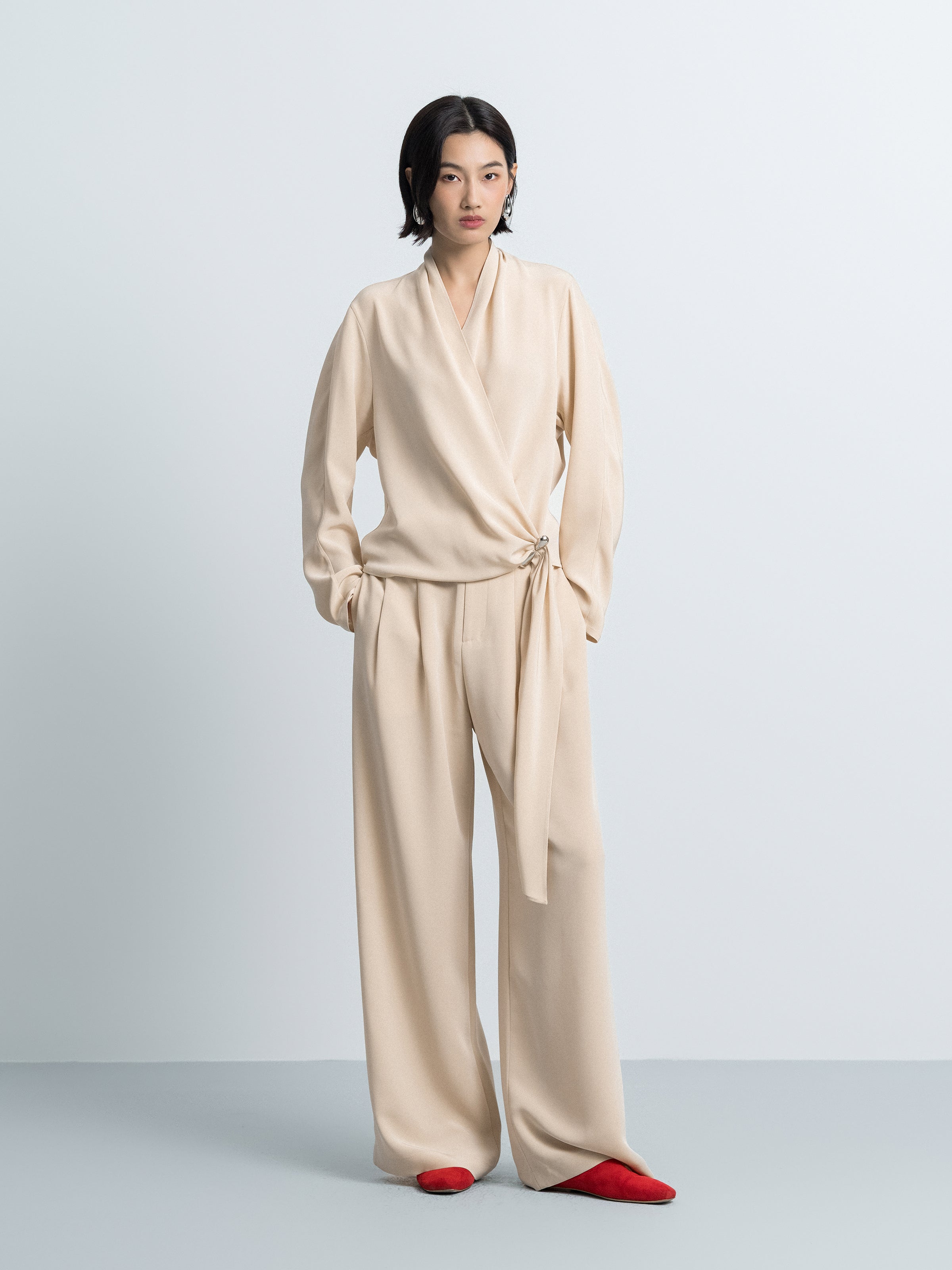 Beige satin wide-leg trousers, tie waist and pleated front.