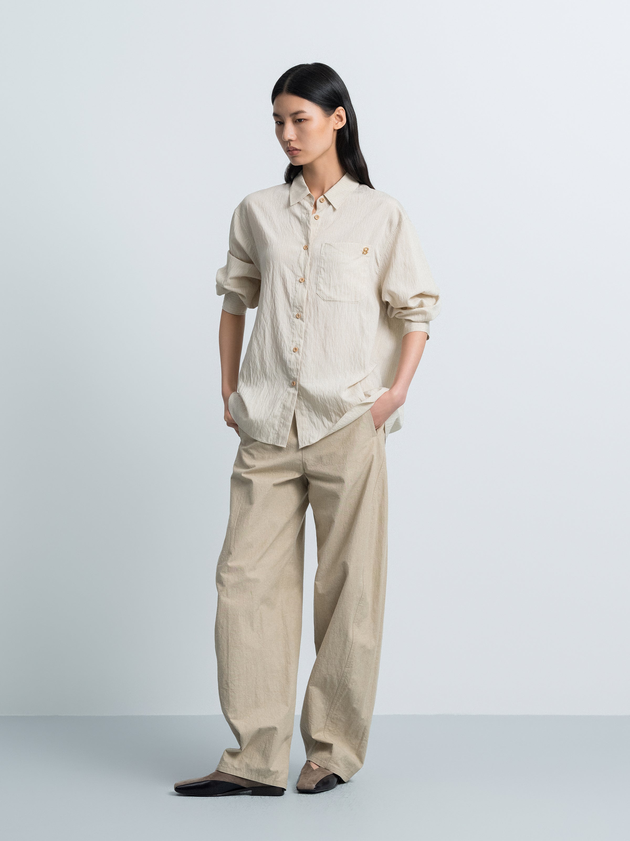 Light beige striped button-up shirt with chest pocket and gold buttons