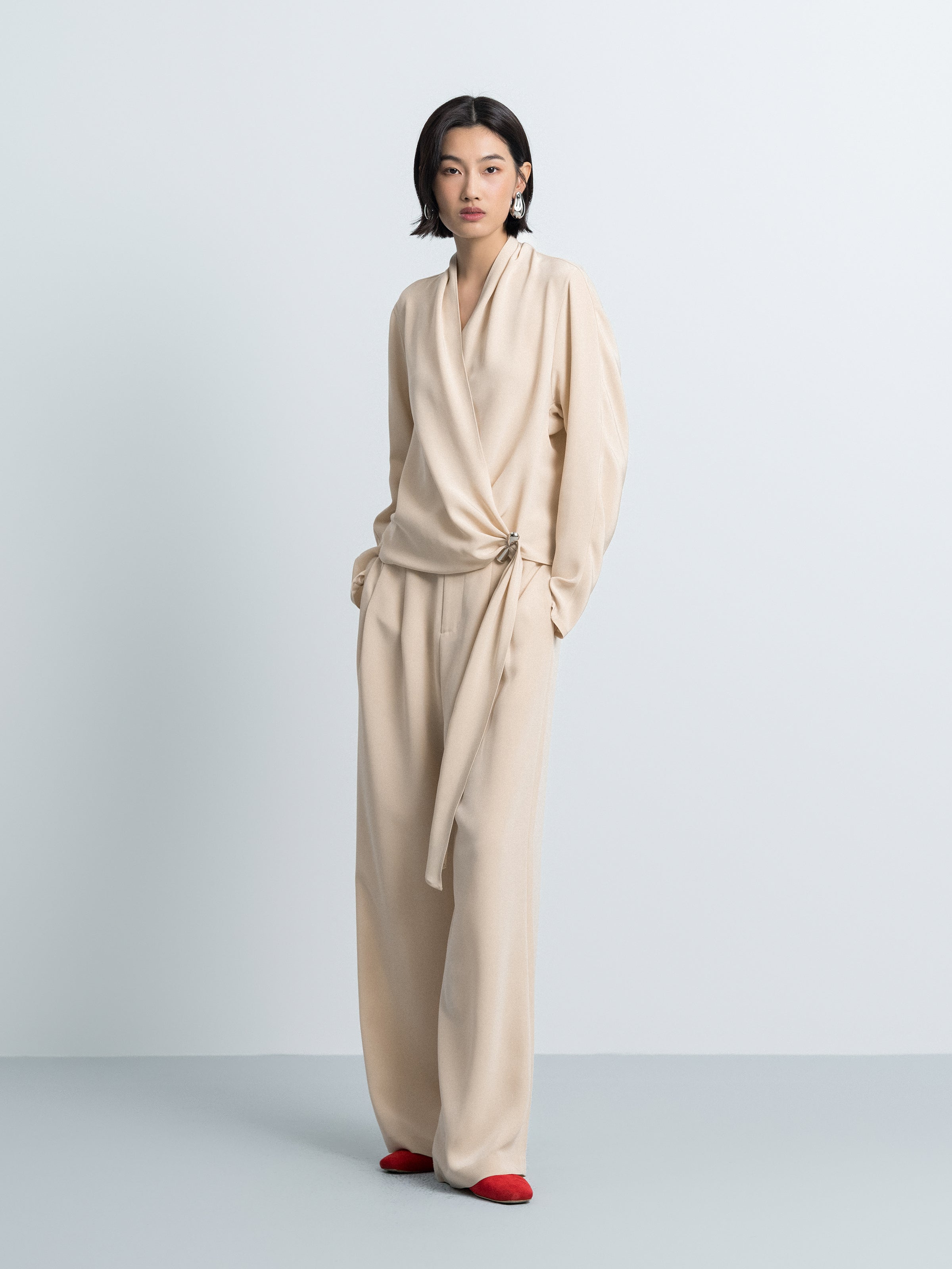 Light beige draped cross-over top with V-neck and gathered waist tie, long sleeves