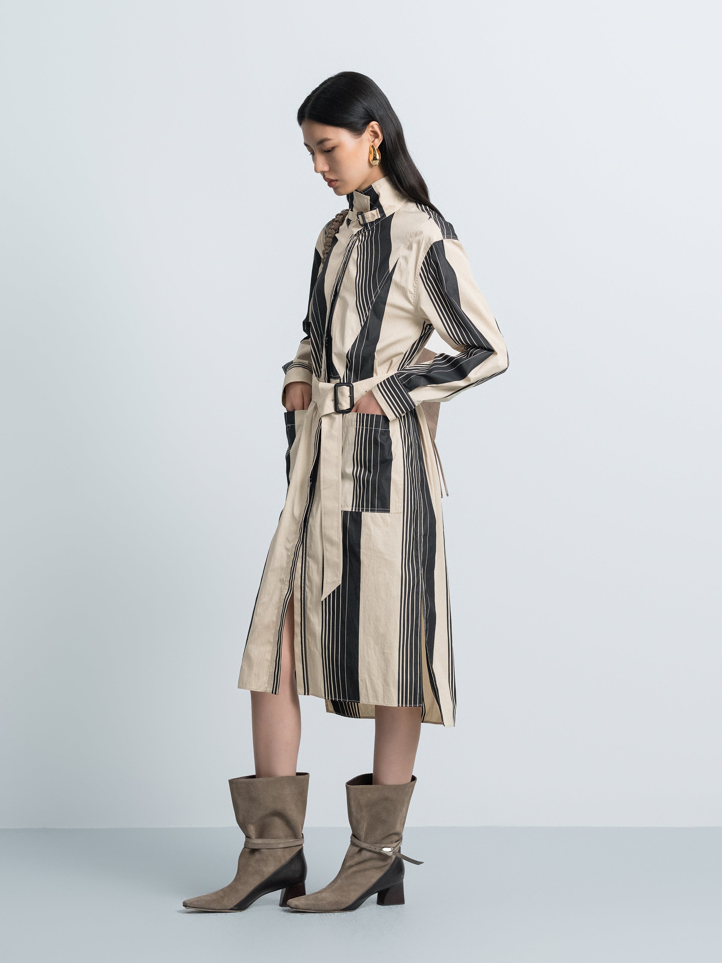Striped trench coat with stand collar, side view, belted waist, vertical black and cream