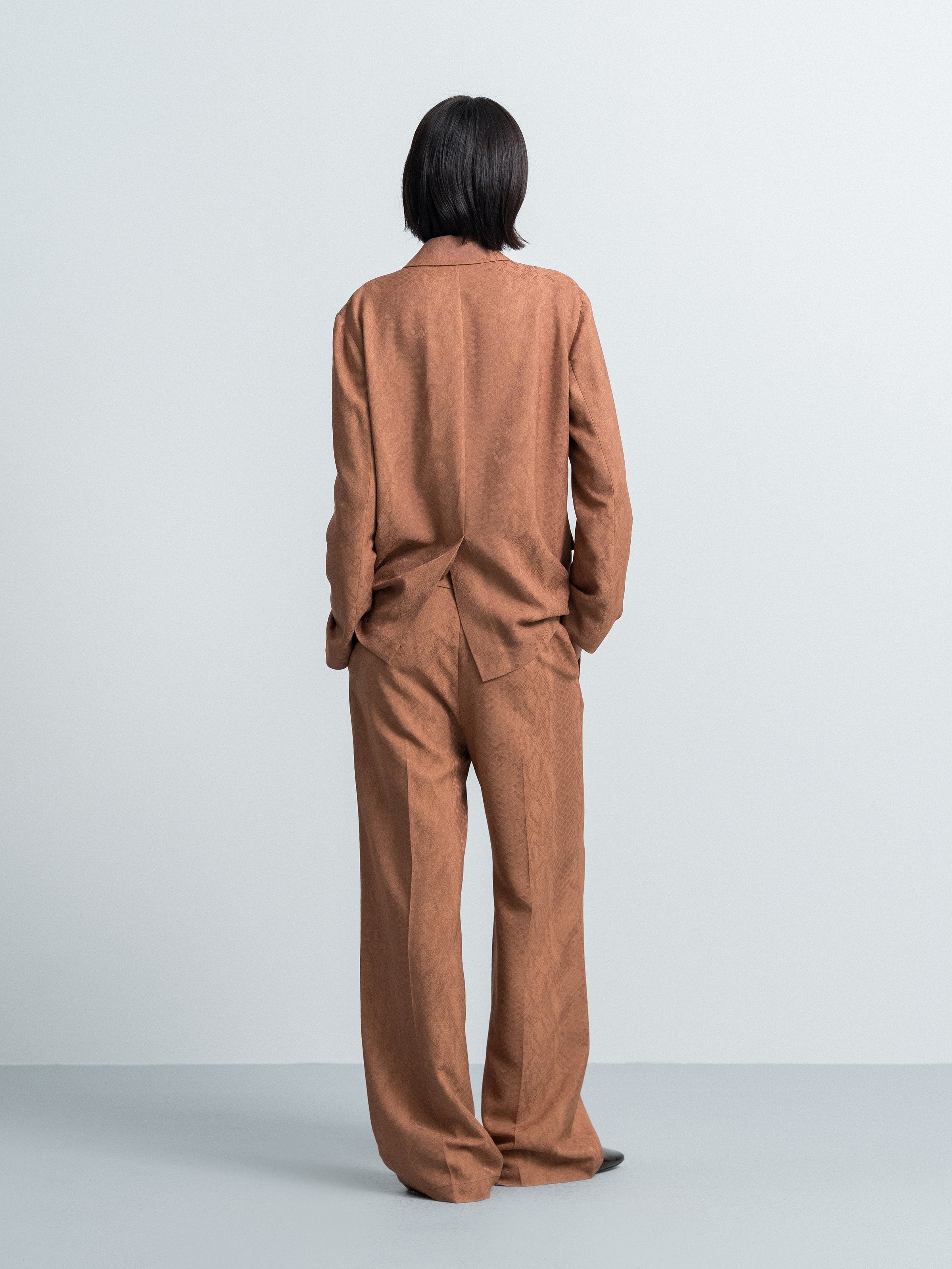 Nude brown wide-leg trousers from back, full length and relaxed fit