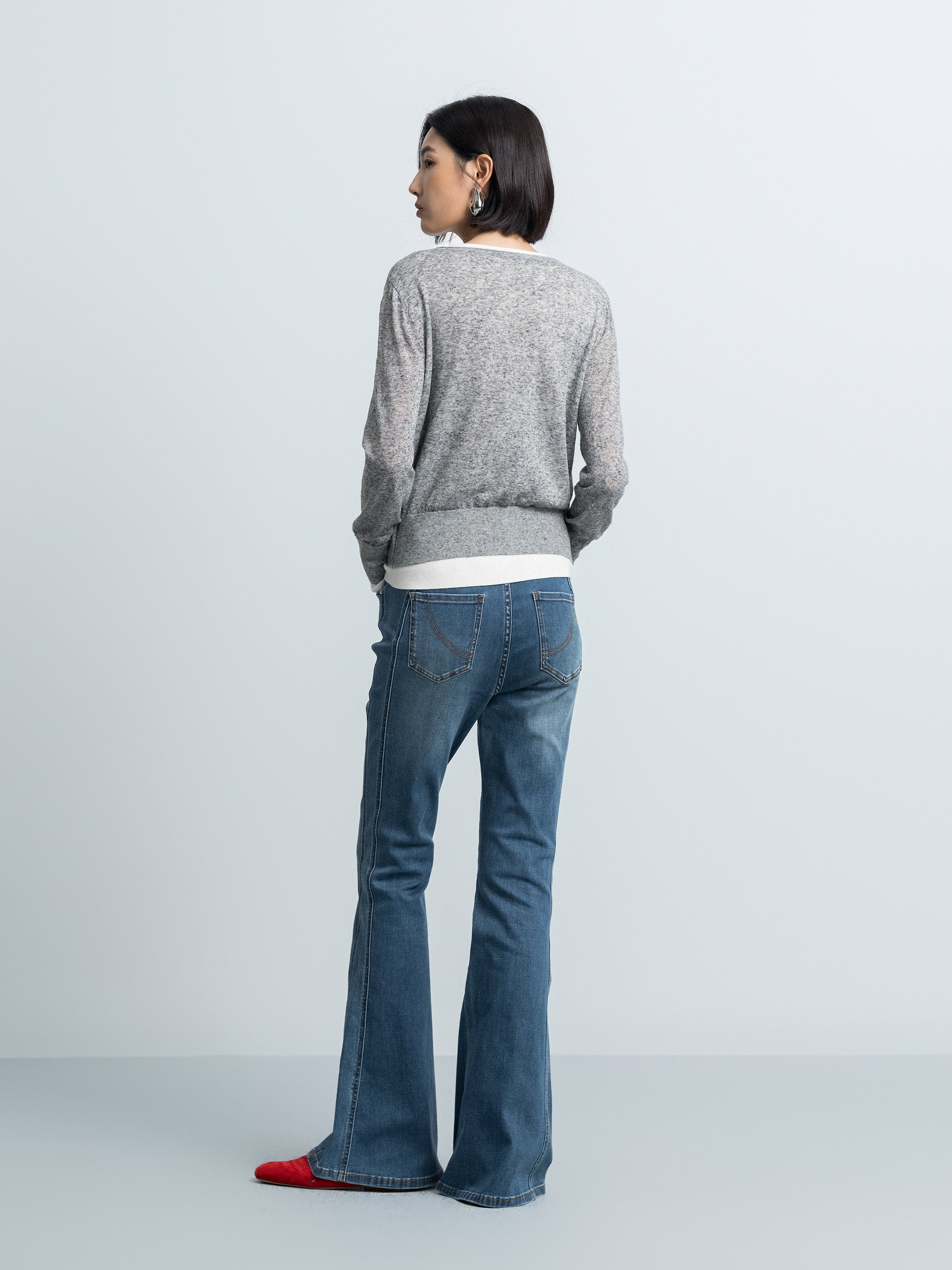 Grey V-neck knit cardigan with contrast cream hem, shown from the back