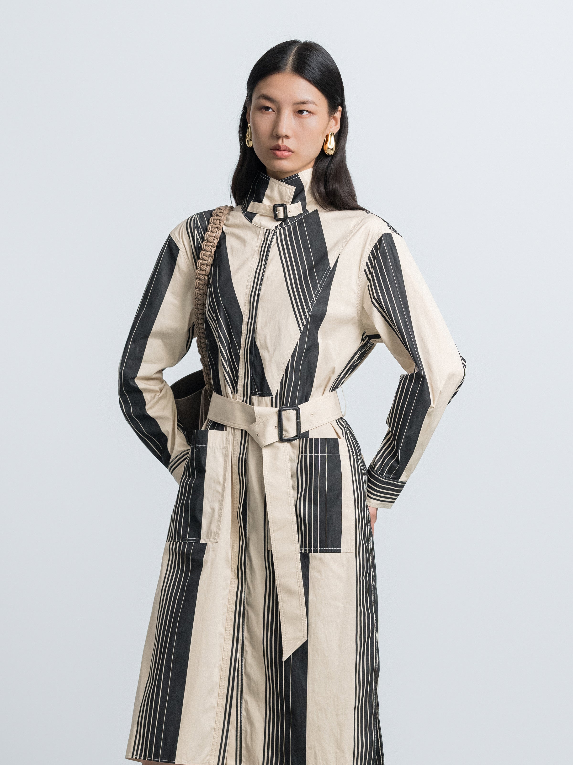 Striped trench coat with stand collar, tie belt at waist, vertical black and cream