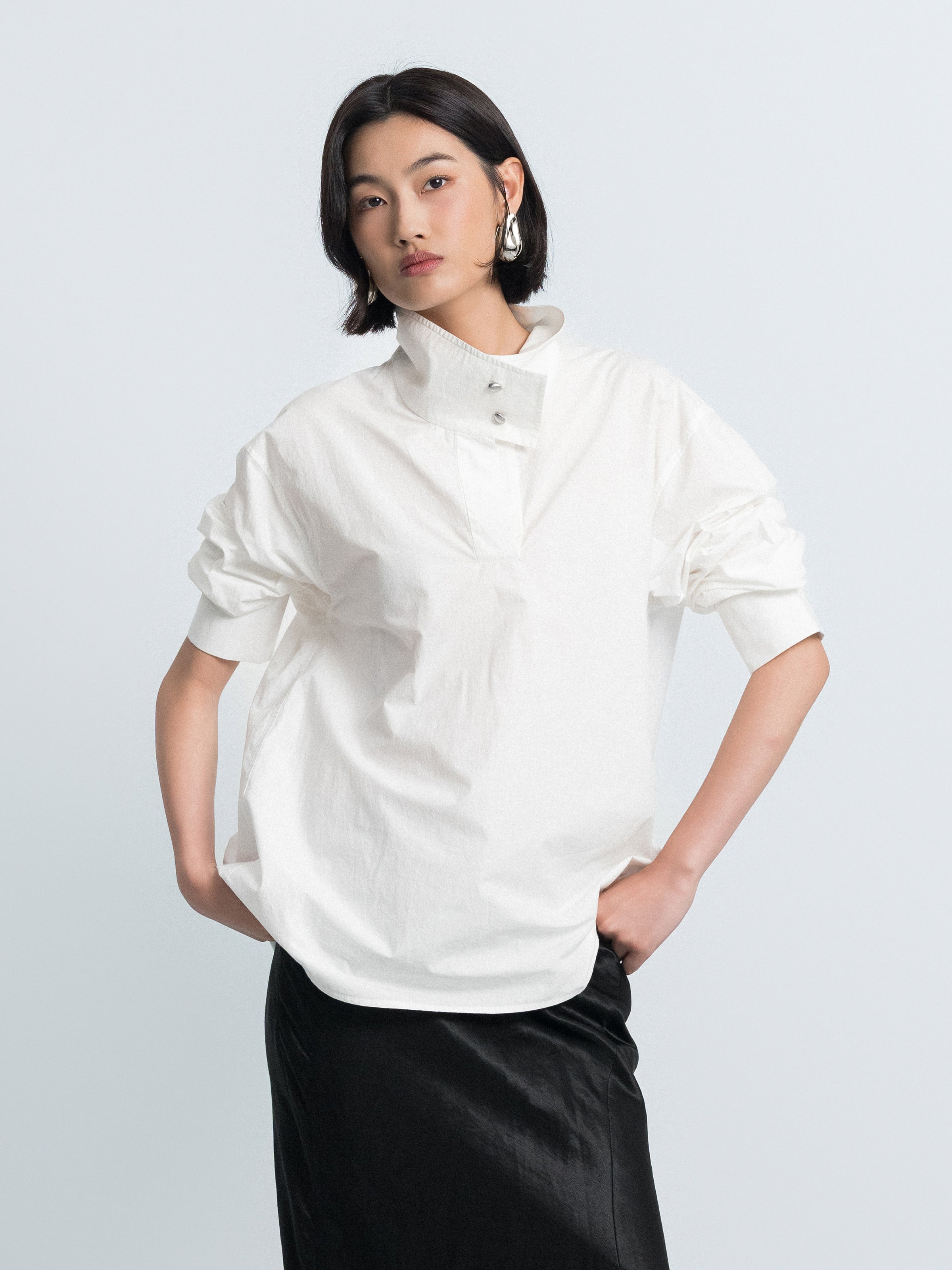 Off-white oversized shirt-style top with stand collar and buttoned chest placket