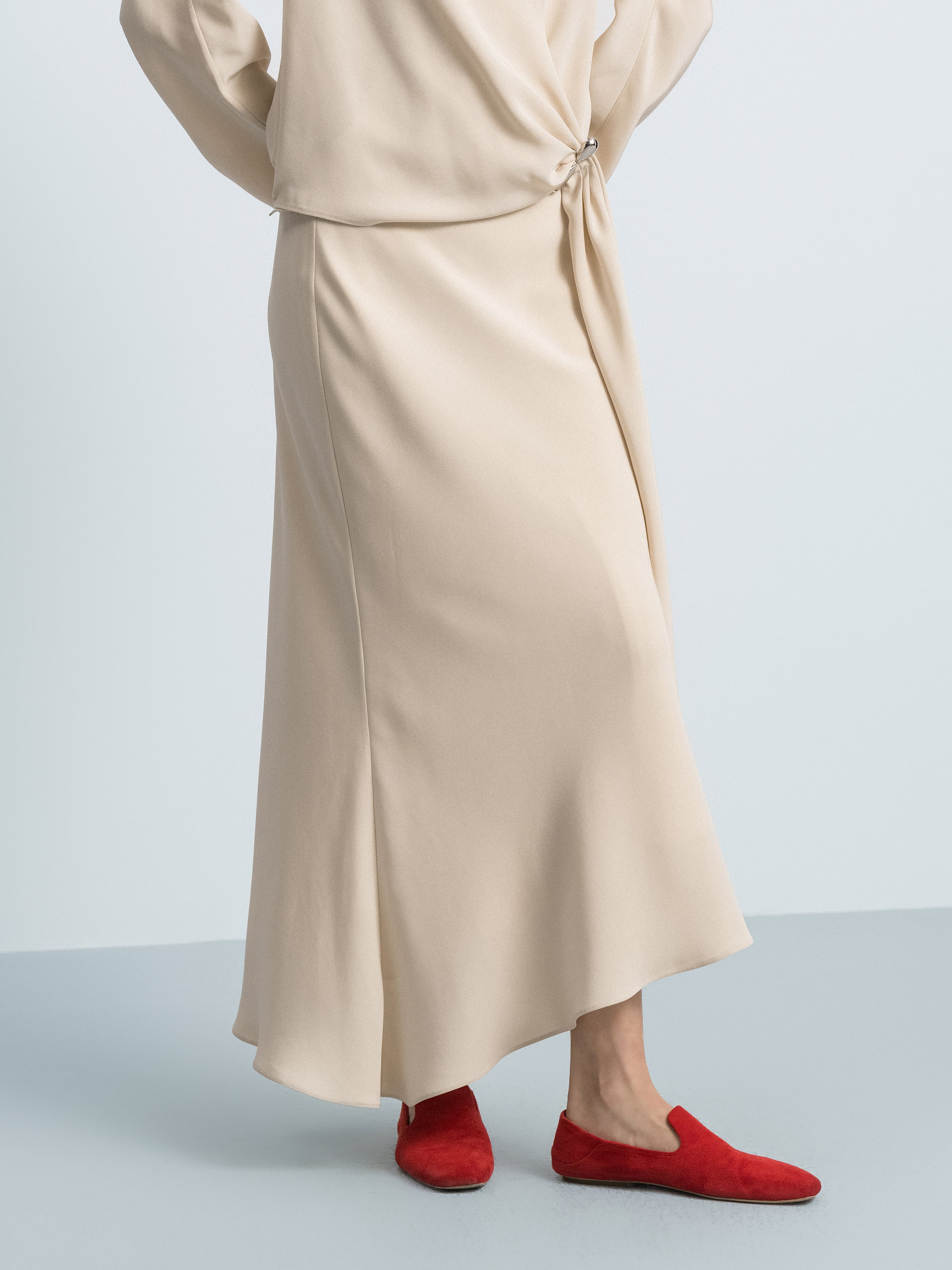Beige yellow mermaid skirt close-up of asymmetric hem and side seam