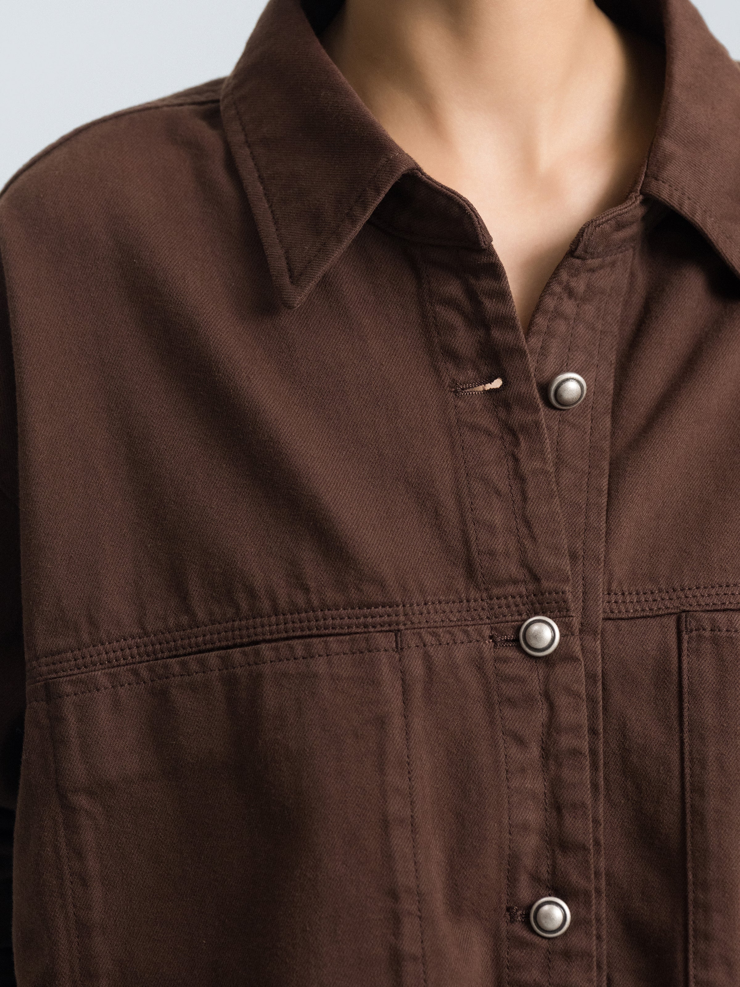 Coffee brown denim shirt detail: metal buttons on button placket