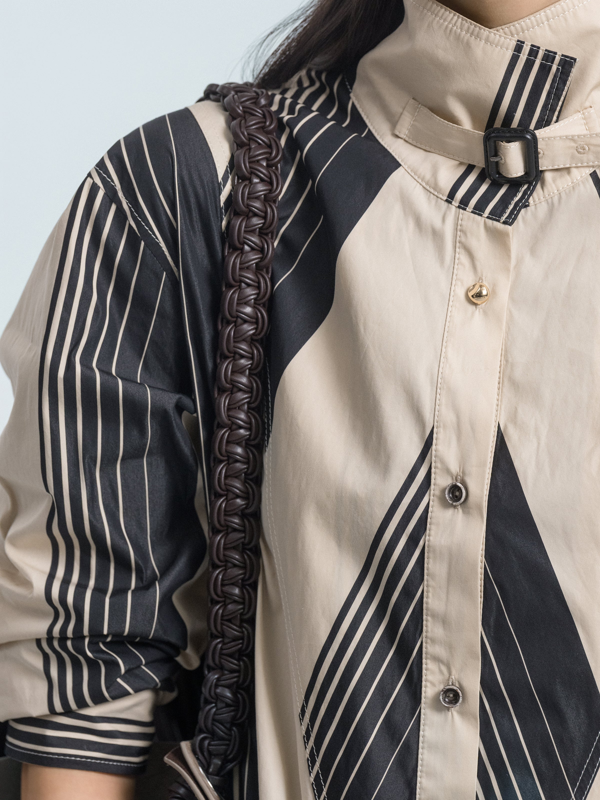 Close-up of cream and black striped shirt with stand collar and button placket